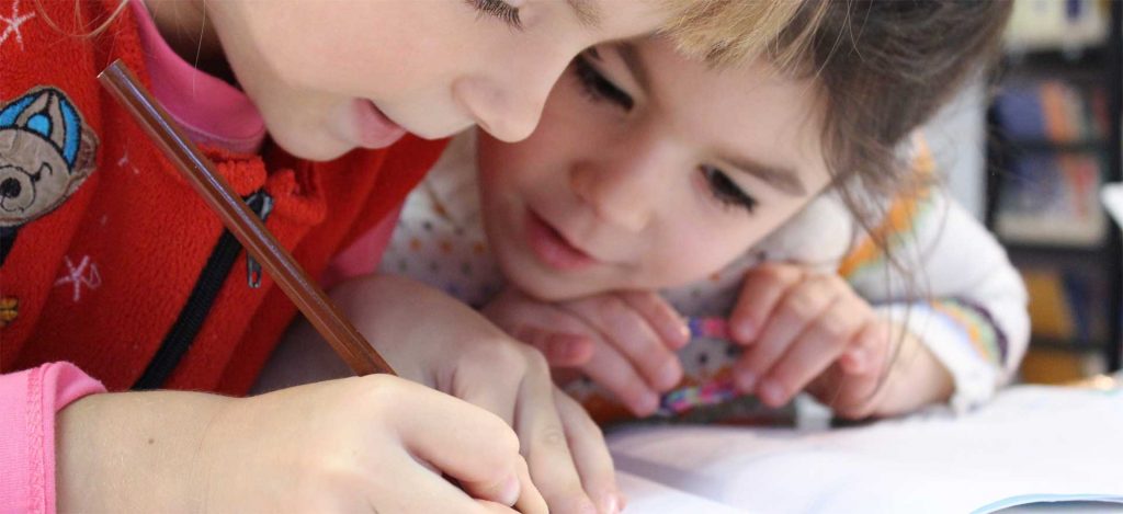 Dos niños anotando en una libreta