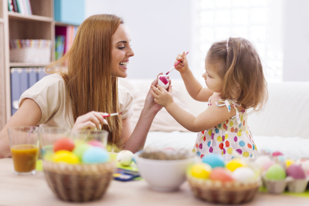 Made e hija pintando huevos 