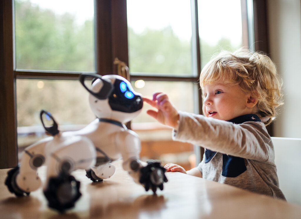 Niño jugando con un perro robot