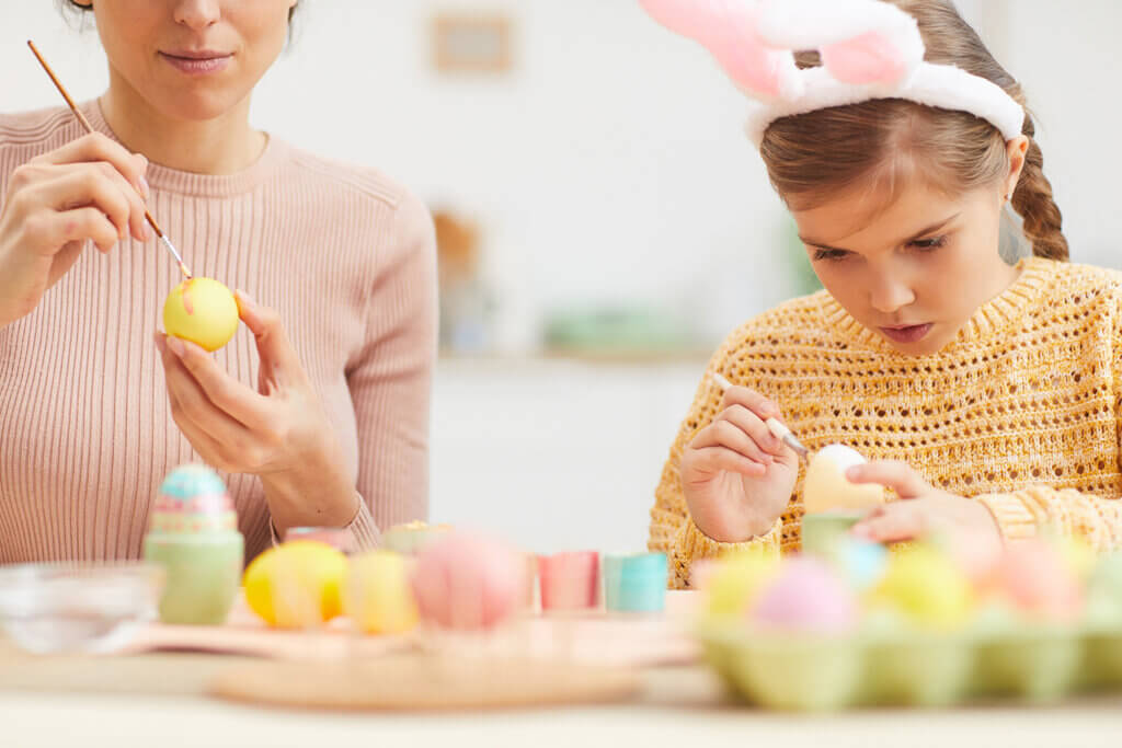 Madre e hija pintando huevos de pascua